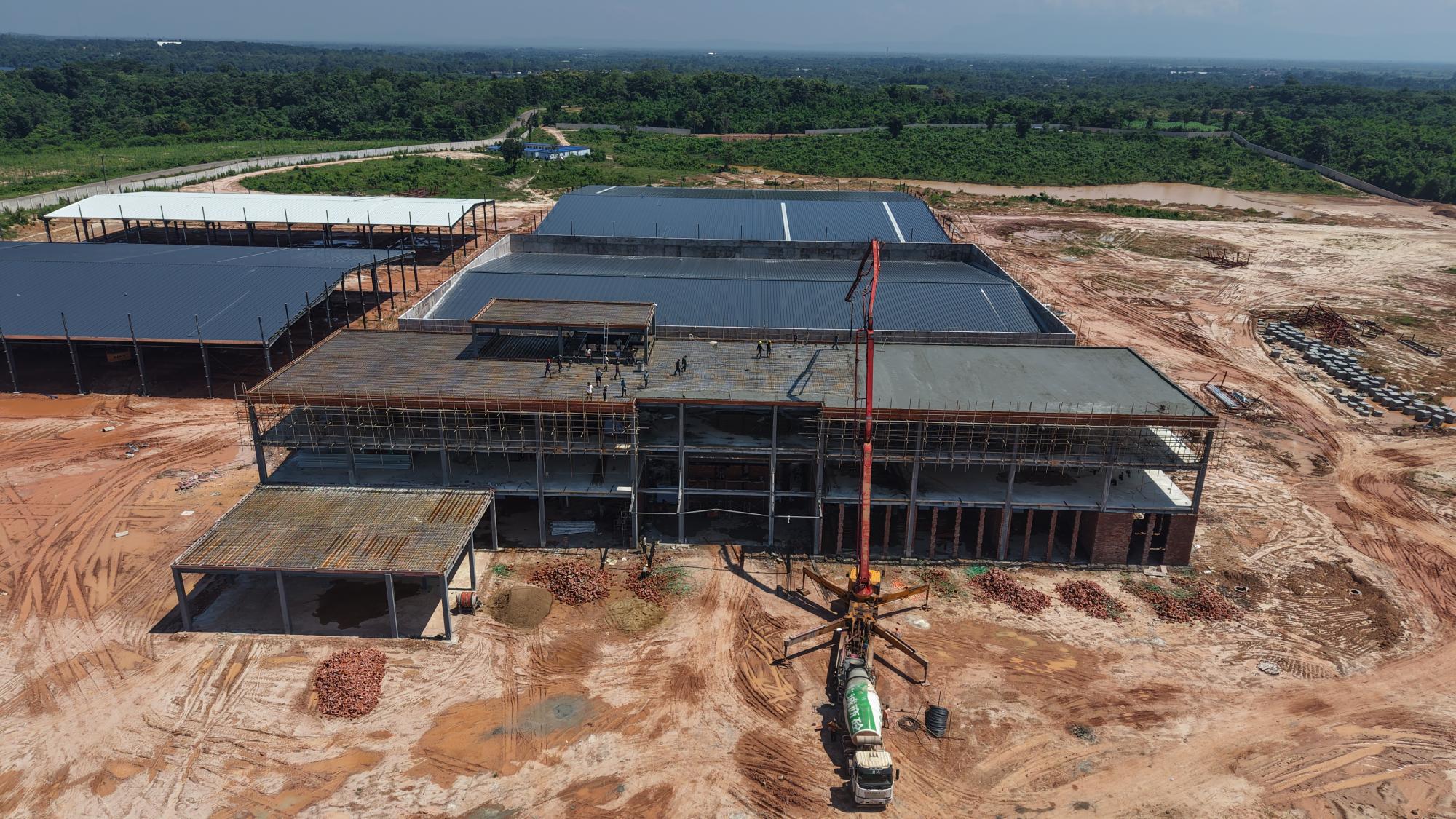 Genuine aerial photograph supplied by Raysun, showing its Vientiane main building under construction, scaffolding and a concrete pump.
